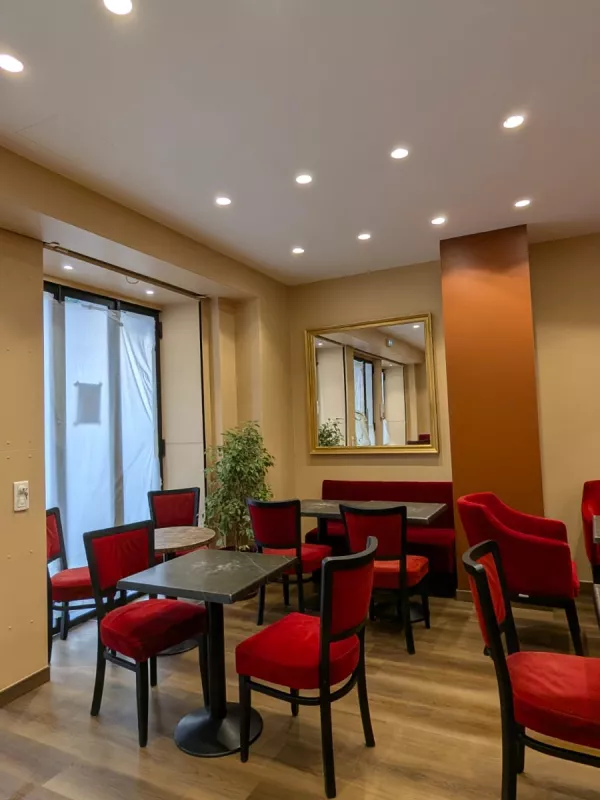 Après : La salle côté vitrine, réchauffée par la palette terracotta et sable