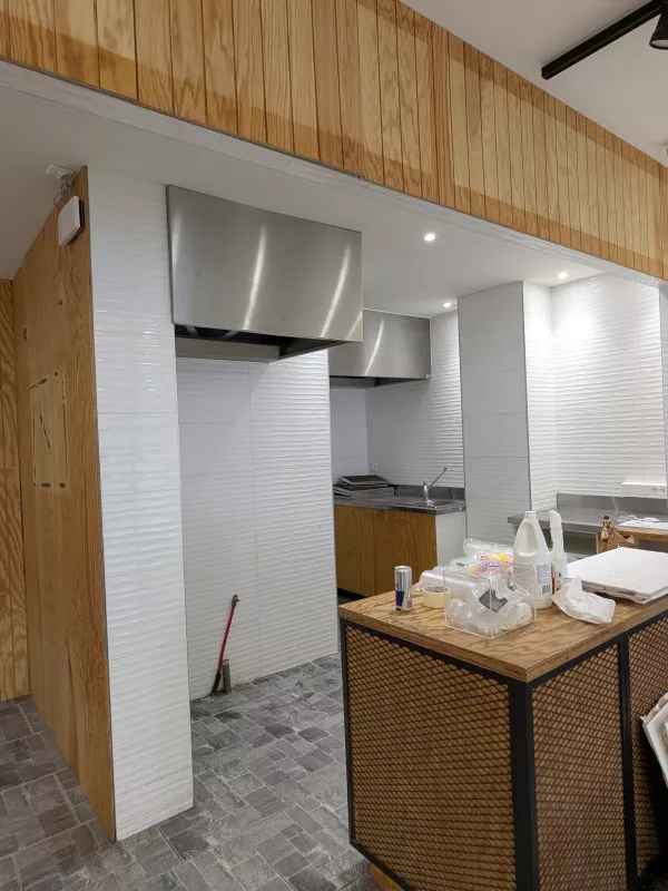 Avant : Le comptoir, repensé avec un habillage en tasseaux de bois et un mur terracotta