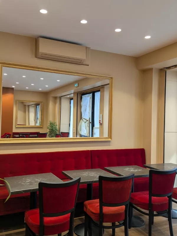 Après : Le mur du fond, devenu une banquette rouge sous un grand miroir doré