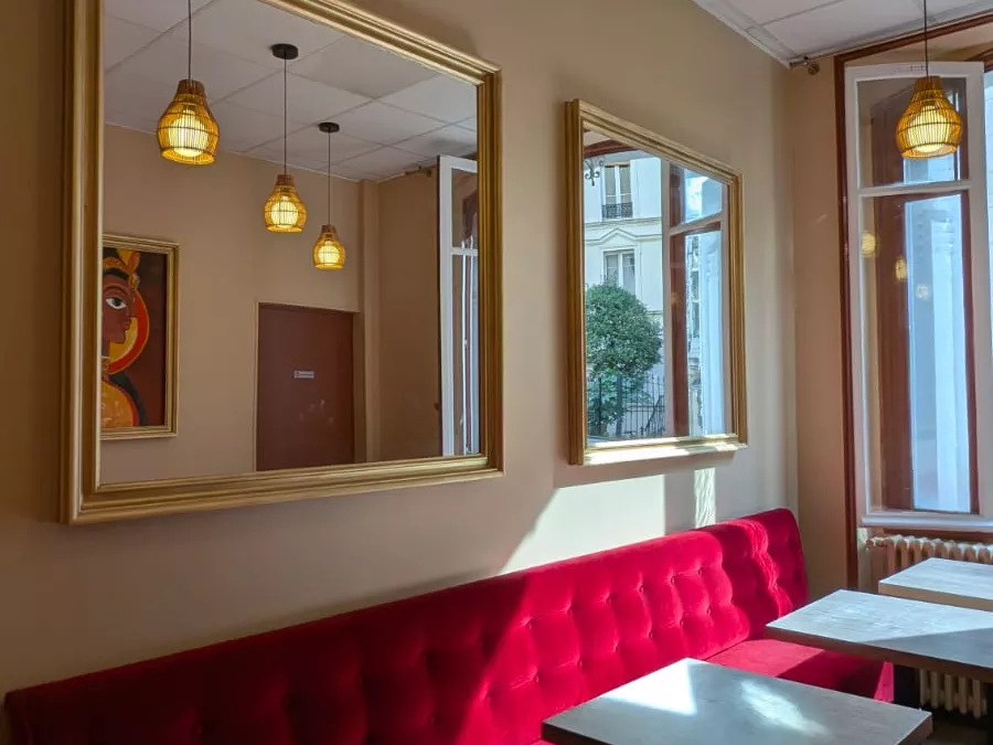 Banquette capitonnée, miroirs dorés et suspensions en rotin