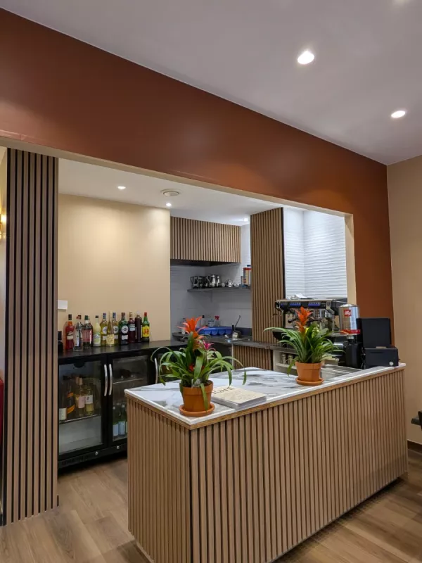 Après : Le comptoir, repensé avec un habillage en tasseaux de bois et un mur terracotta
